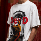 A person wearing a white oversized graphic T-shirt with a large red and black print featuring the text 'DevD' and a stylized figure, photographed against a textured red-brown background.